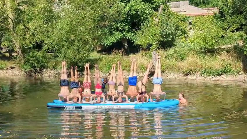 personnes en poirier sur un paddle géant